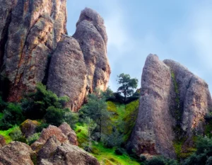 Majestic rock formations in mountains with backdrop of vibrant green forest.