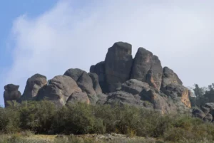 A majestic rock formation stands tall in a field within the National Park.
