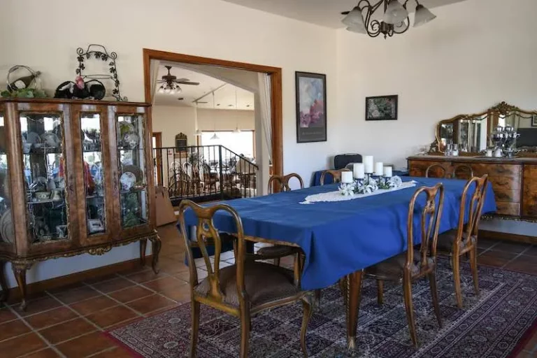 A dining room with a blue table and chairs, adorned with candles.