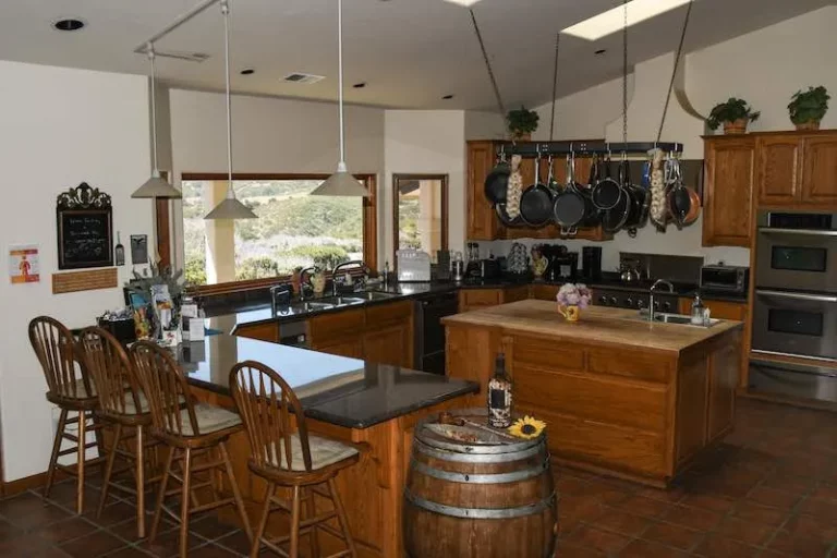 Traditional kitchen at Inn at the Pinnacle showcasing wine barrel and chairs.