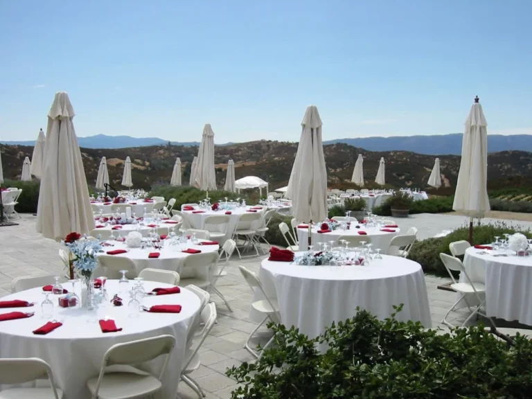 A large table with white cloths set up for a wedding reception.