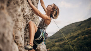 Rock climbing on a steep cliff with safety gear.